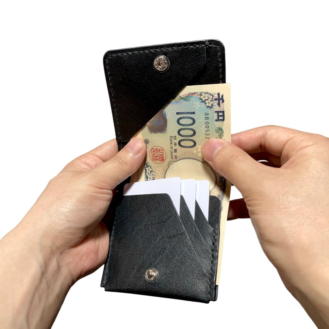 縦型二つ折り財布 薄型ミニマリスト財布 お札とカード専用 お札を取り出している様子
