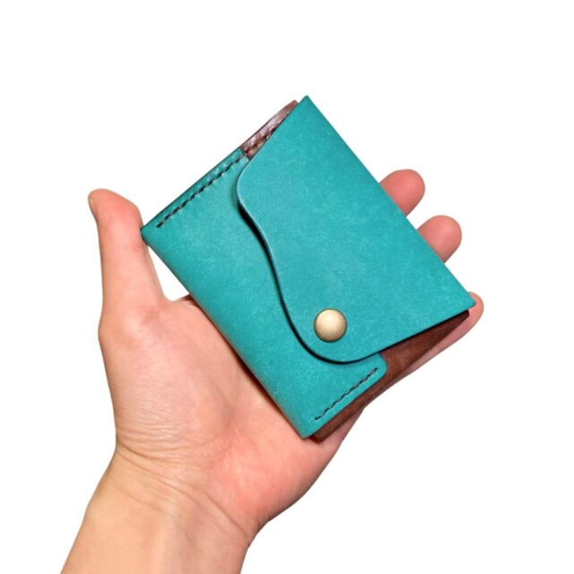 4色のイタリアンレザー クロスフラップミニウォレット 手に持った状態