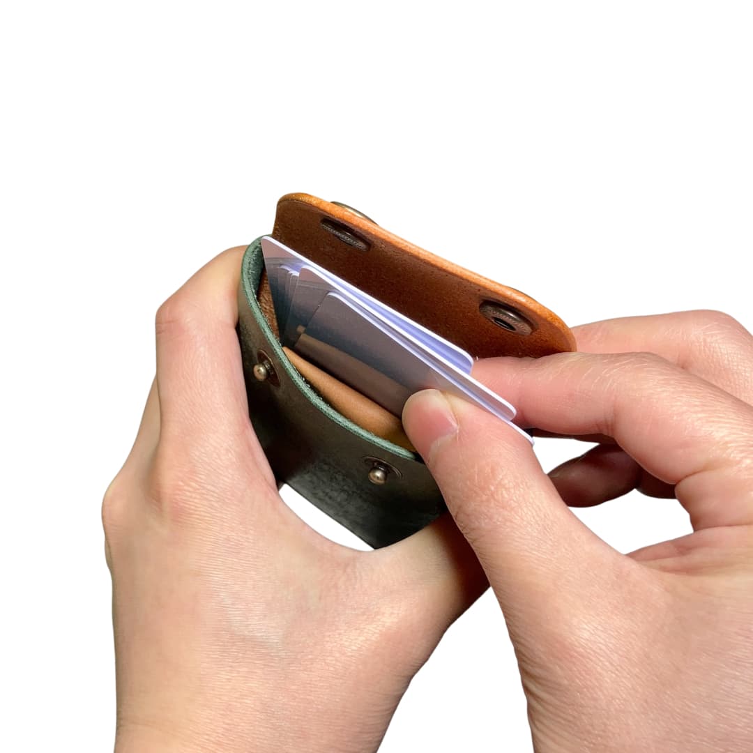 ダークグリーン キャメル クロスフラップミニウォレット 手に持った状態